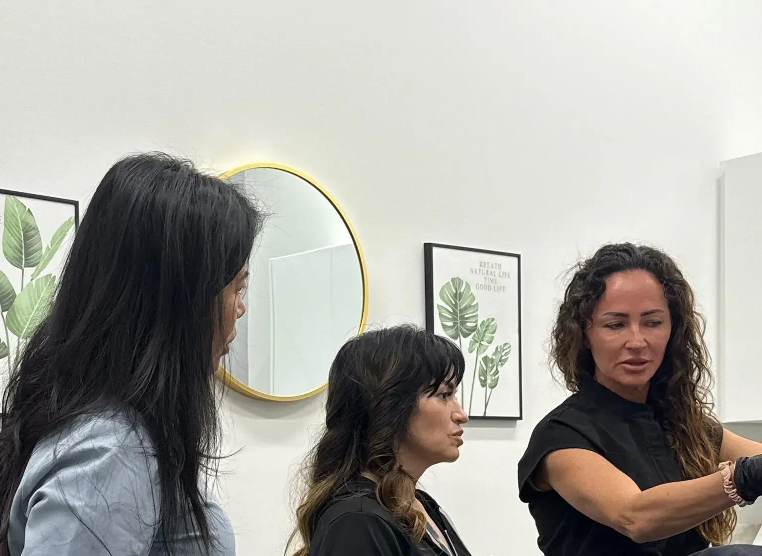 Advanced aesthetic nurse teaching a small group of injectors in a bright treatment room